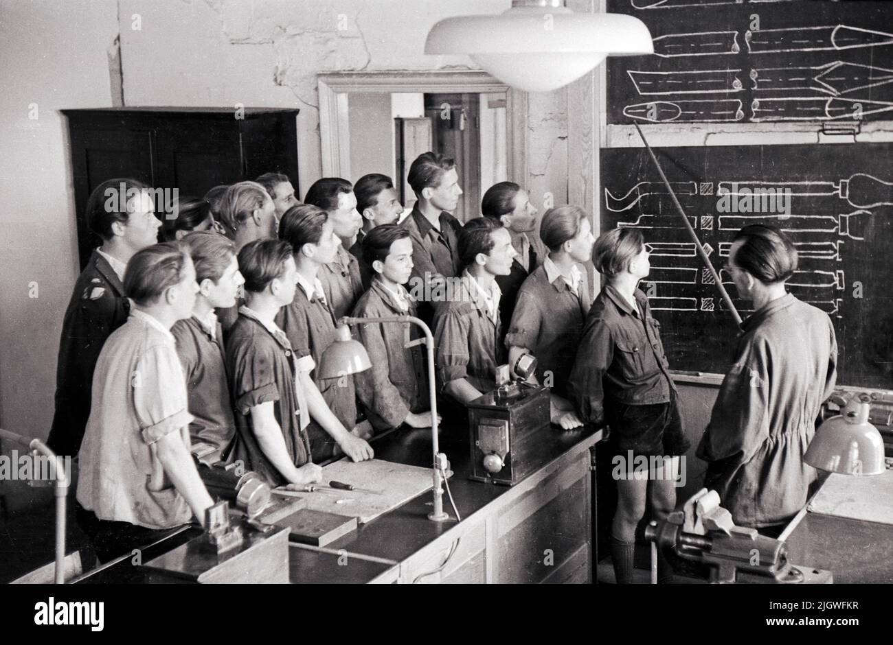 Original-Bildunterschift: Fernmelde- und Telegrafenbau-Lehrlinge auf der Schulbank: Lehrlinge verfolgen die Stromläufe eines Tischfernsprachers, die von ihnen selbst gezeichnet wurden, Berlin, Allemagne 1947. Banque D'Images