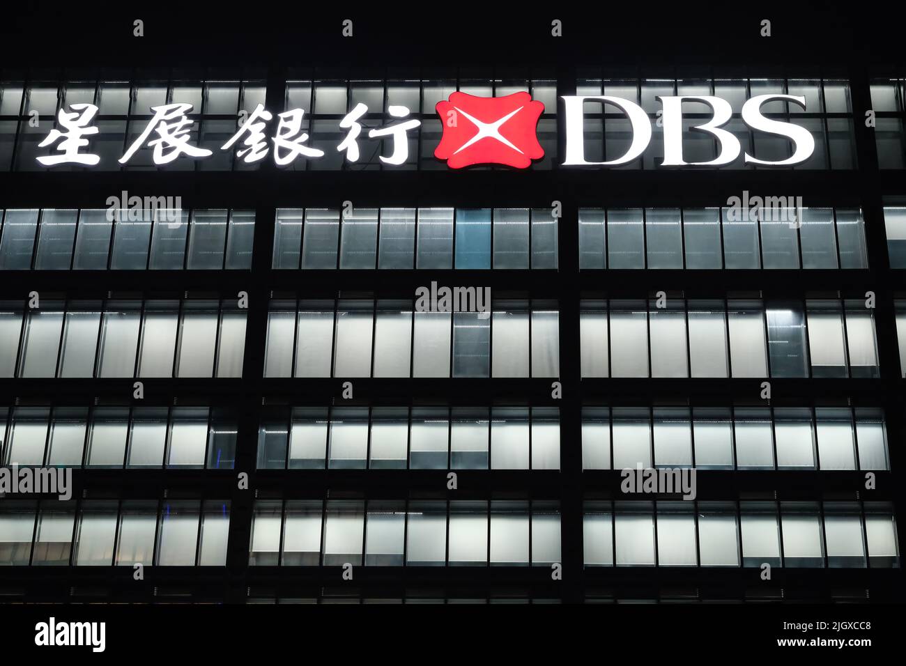 Shanghai,Chine-février 2022: Façade du bâtiment de bureau de la société DBS Bank et logo la nuit. Une société de services bancaires et financiers singapourienne Banque D'Images
