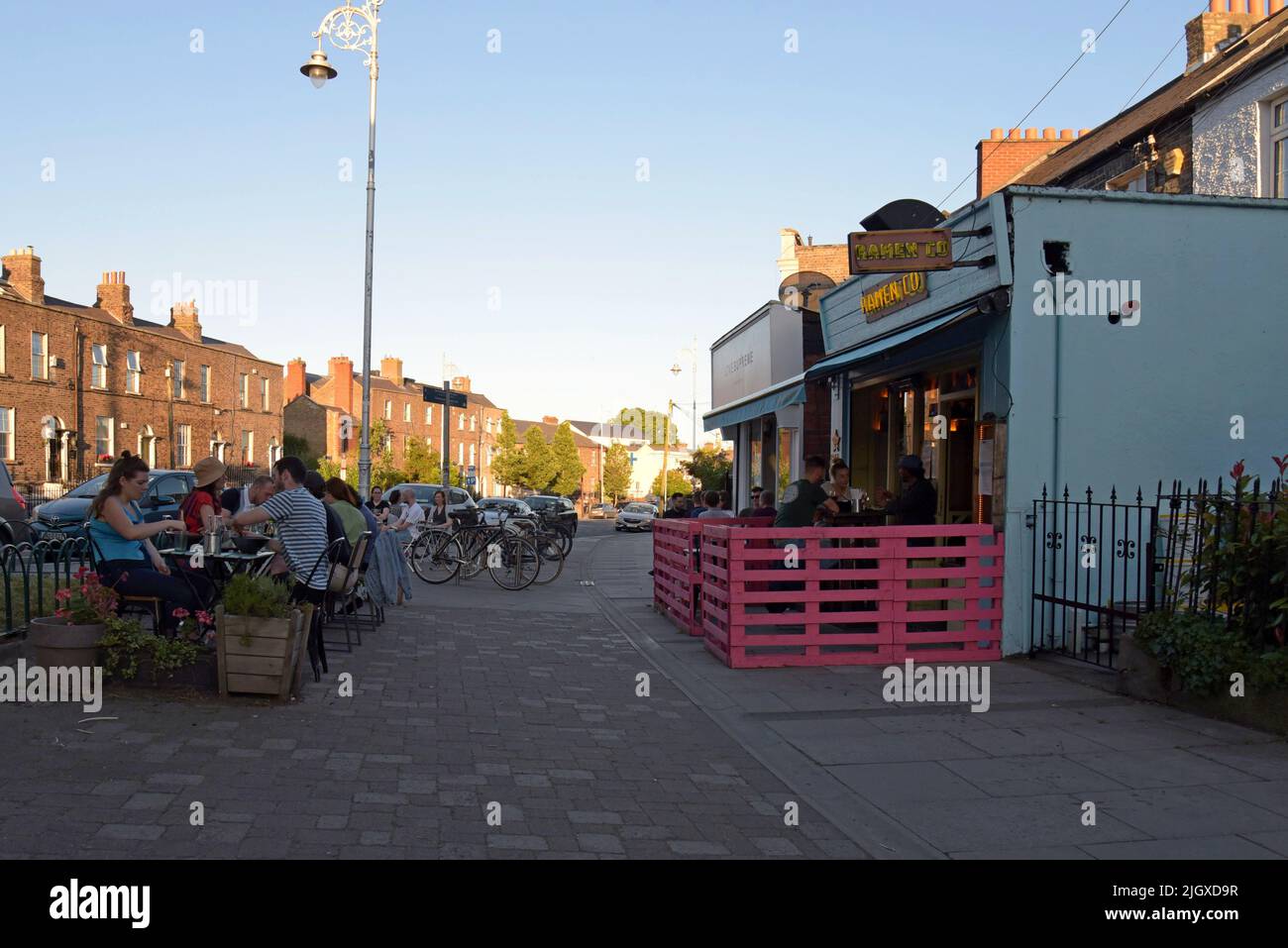 Les personnes dînant à l'extérieur sur le trottoir dans le quartier branché du centre-ville de Stoneybatter, Dublin, Irlande, juillet 2022 Banque D'Images