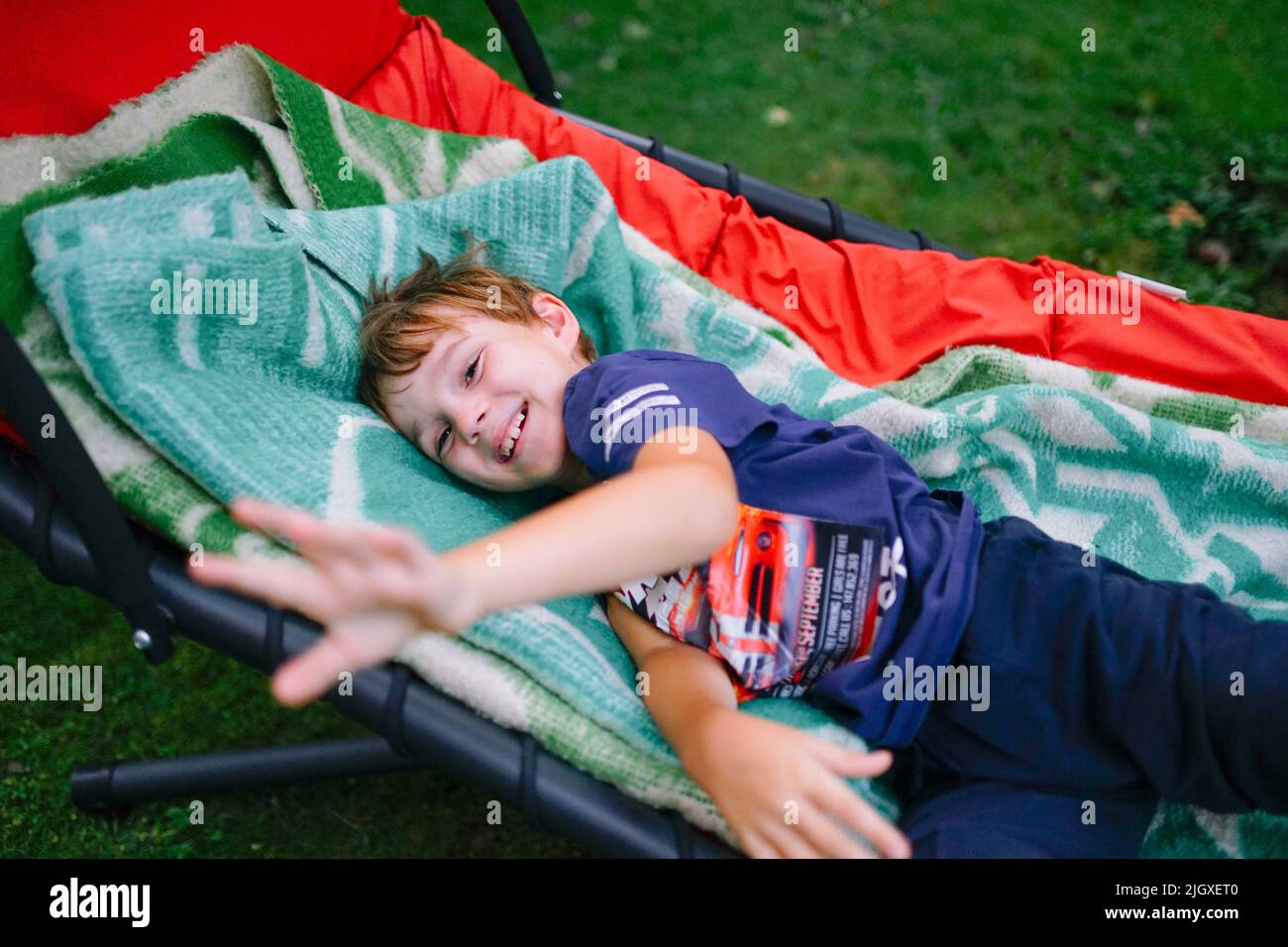 enfant heureux jouant allongé dans un hamac Banque D'Images