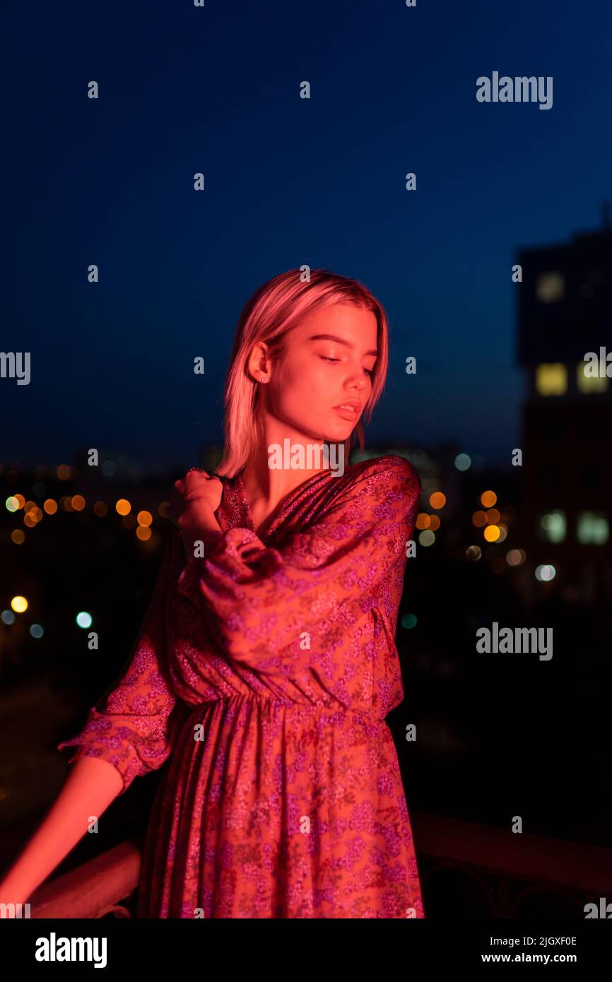 Femme dans une robe sur le fond de la ville de nuit Banque D'Images