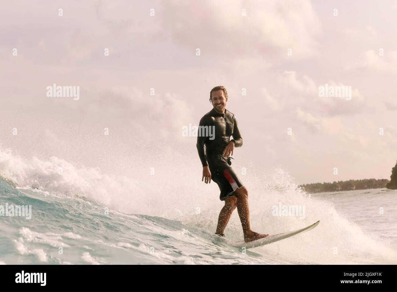 Surfeur mâle sur une vague, Maldives Banque D'Images