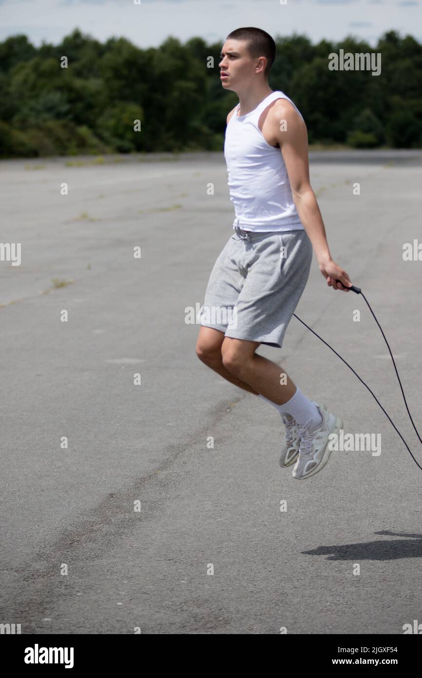 Un adolescent de 1919 ans utilisant Une corde à sauter dans Un parc public Banque D'Images