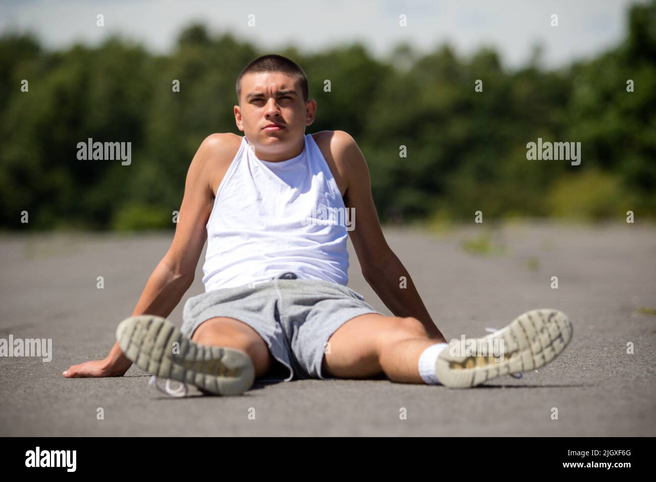 Un adolescent de dix-neuf ans assis dans Un parc public Banque D'Images