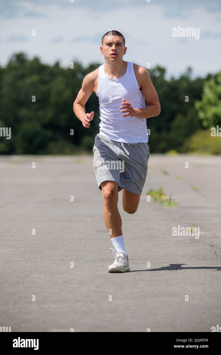 Un garçon adolescent de 1919 ans qui fait du jogging dans Un parc public Banque D'Images