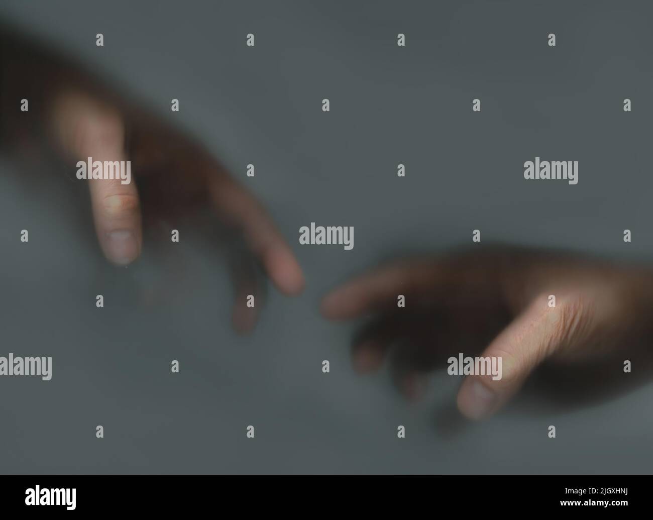 Deux mains se touchant l'une à l'autre dans la brume Banque D'Images