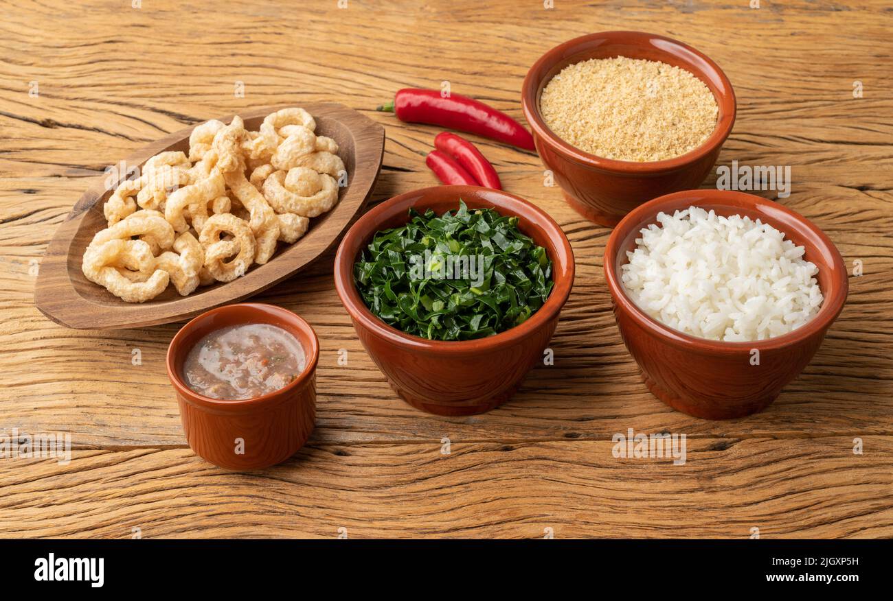 Plats d'accompagnement typiques de la feijoada brésilienne. Riz, kale, poivre, farofa et crépitements. Banque D'Images