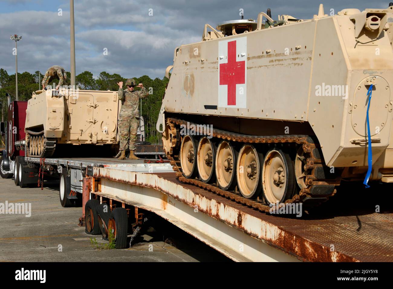 Fort Stewart, Géorgie, États-Unis. 21st avril 2022. Un soldat de l'armée américaine affecté au sol de la division d'infanterie de 3rd guide un soldat qui conduit un transporteur militaire de M113 sur un camion à plateau à fort Stewart, en Géorgie, en 21 avril 2022. La pièce d'identité de 3rd a cédé les véhicules blindés pour répondre aux exigences de la réponse présidentielle pour le Théâtre européen des opérations dans le but de fournir une assistance militaire immédiate à l'Ukraine. Crédit: Armée américaine/ZUMA Press Wire Service/ZUMAPRESS.com/Alamy Live News Banque D'Images