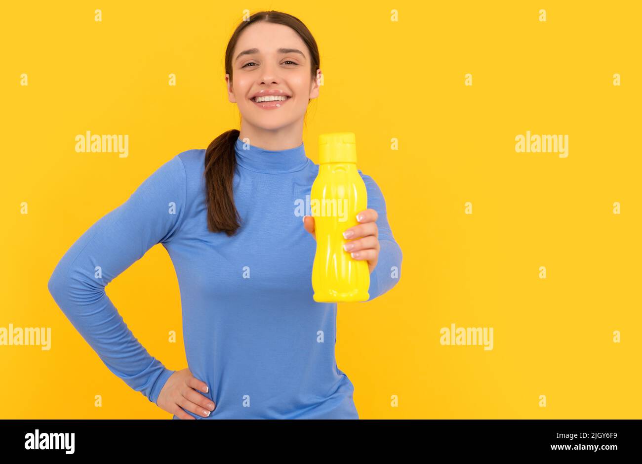 bonne jeune fille offre bouteille de sport avec eau, hydratation Banque D'Images