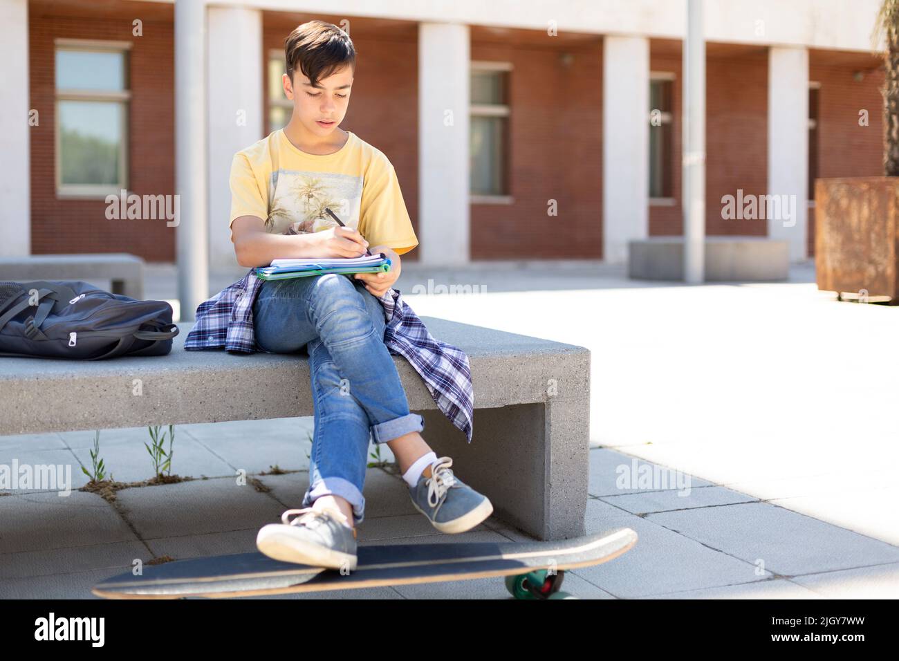 Adolescent de race blanche qui fait ses devoirs avant d'entrer à l'école secondaire. Enseignement secondaire. Espace pour le texte. Banque D'Images