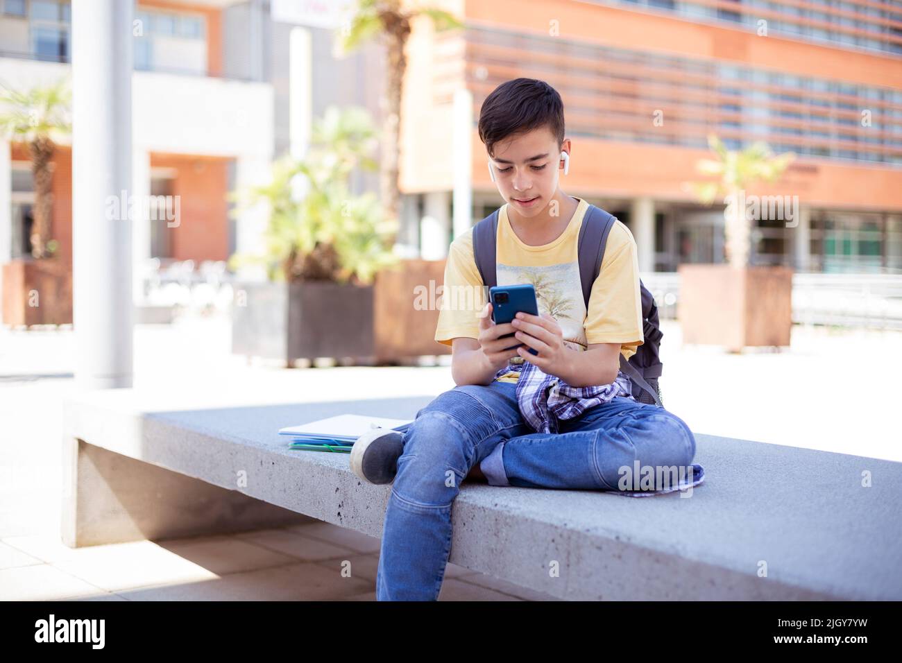 Un adolescent de race blanche utilisant un smartphone à l'extérieur. Espace pour le texte. Banque D'Images