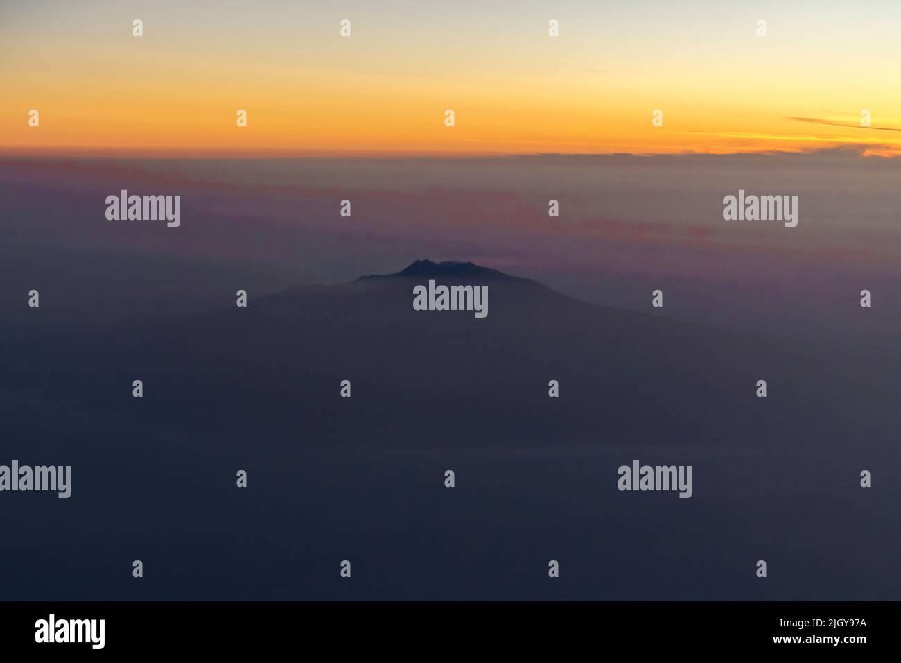 Mont Etna au-dessus des nuages au coucher du soleil Banque D'Images