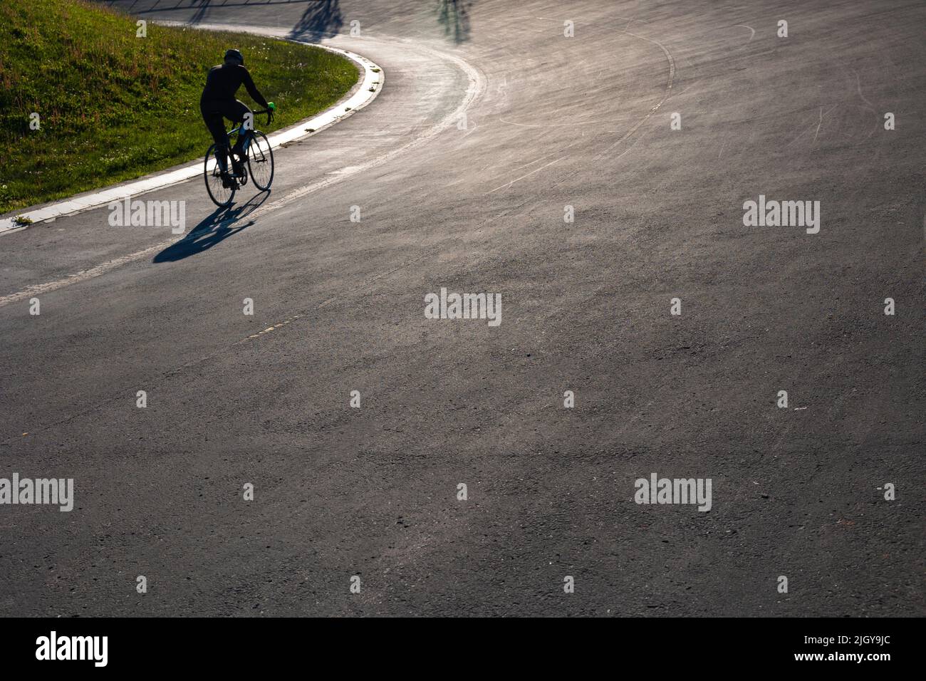 Silhouette d'un cycliste sur la piste de course cycliste du parc. Photo de fond de style de vie sain. Banque D'Images