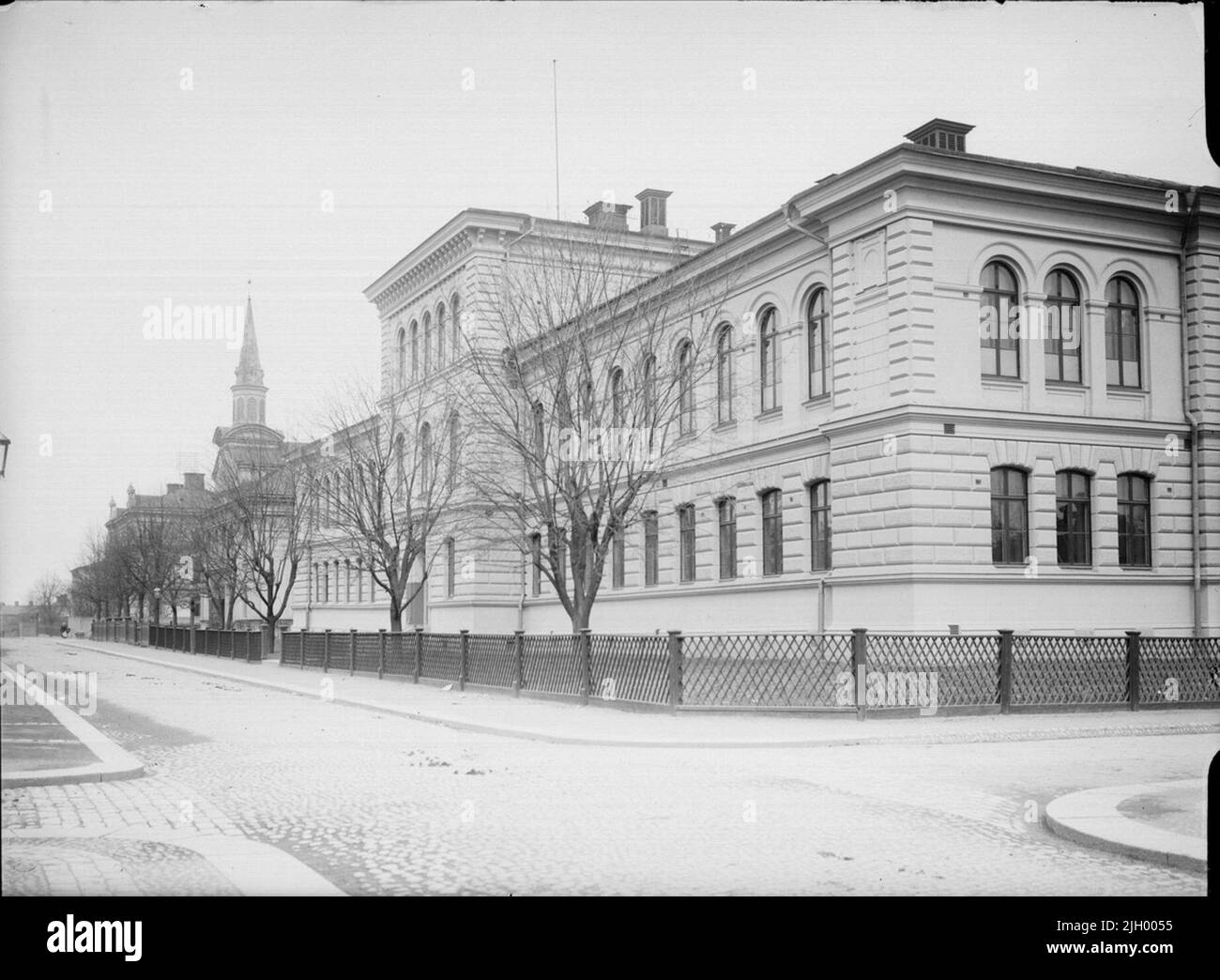 Kungsgatan au nord de Saint Olofsgatan, Dragarbrunn, Uppsala 1901 - 1902. Kungsgatan au nord de Järnbrogatan (St. Olofsgatan). Le bâtiment monumental de l'école primaire dans le quartier de Balder est érigé après les dessins de C A Kihlberg de 1883. C'est aujourd'hui le seul bâtiment conservé de l'école primaire d'Uppsala à partir de la fin de 1800s, lorsque le système de l'école primaire dans la ville a subi une forte rénovation. 'D'Ola Ehn & Gunnar Elfström, au tournant du siècle, les photos d'Uppsala i Dahlgren. Nature et culture 1977. Architecte: Kihlberg, Carl August Banque D'Images
