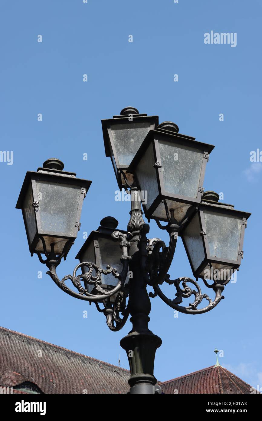 l'ancien latern contient cinq lampes séparées pour éclairer la nuit. photo prise à bavière, lindau avec ciel bleu devant un bâtiment historique Banque D'Images