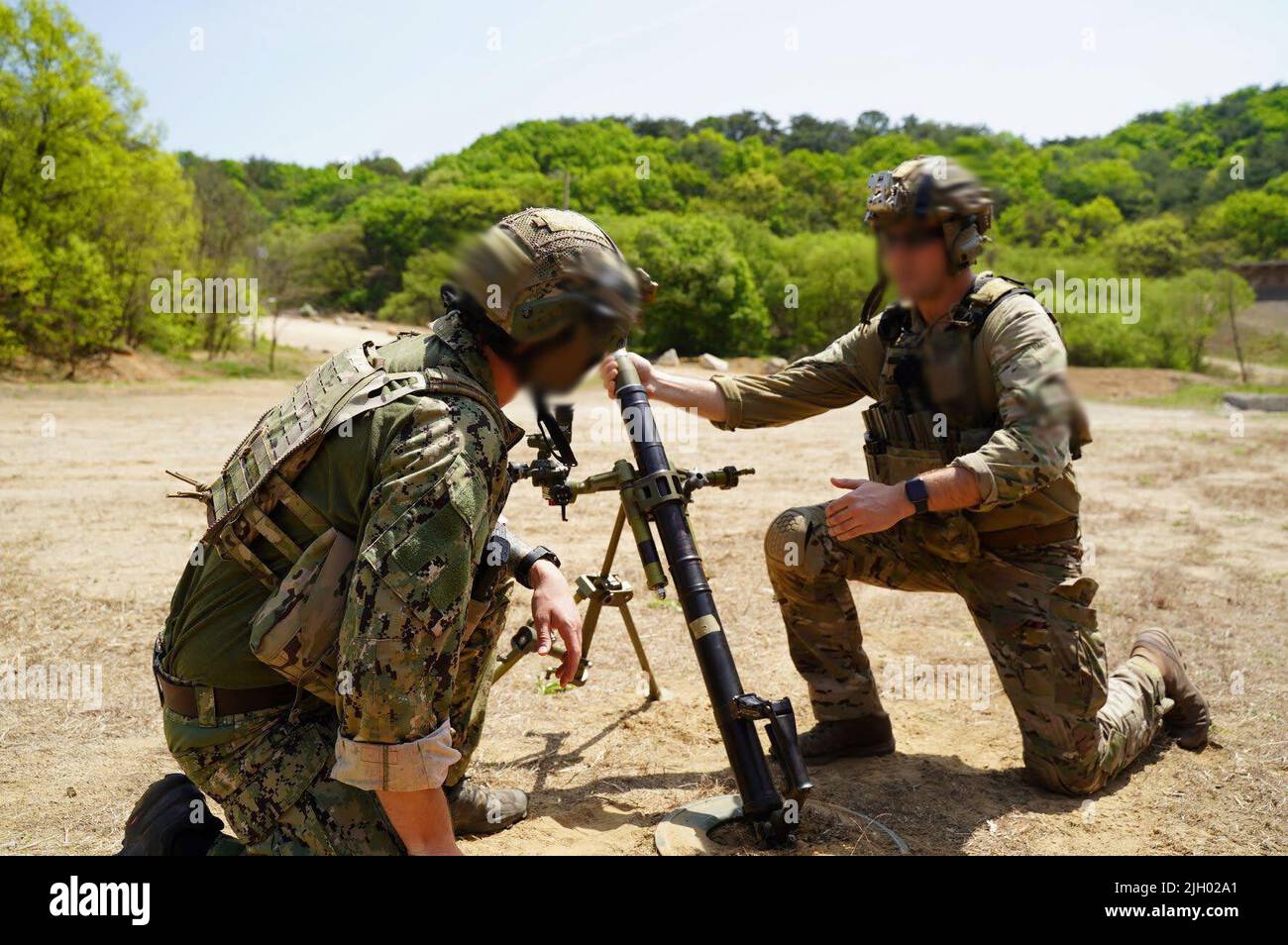 Des bérets verts avec 1st membres du Groupe des forces spéciales (aéroportés) et des techniciens d'élimination des munitions explosives avec l'unité mobile d'élimination des munitions explosives de la Marine 1 chargent un système de mortier au complexe de tir direct de Rodriguez, République de Corée, 27 avril 2022. Les membres du service ont suivi une formation croisée et ont engagé des objectifs au-delà de 2000 mètres. La formation est conçue pour améliorer la létalité des unités en dehors de l’environnement de combat des quartiers étroits. (É.-U. Photo de courtoisie de l'armée) (cette photo a été modifiée à des fins de sécurité.) Banque D'Images