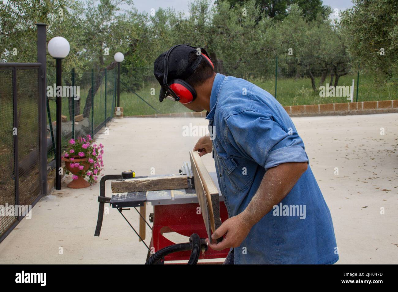 image d'un ouvrier de main coupant des planches de bois avec une scie à table. Travaux de menuiserie et de construction Banque D'Images