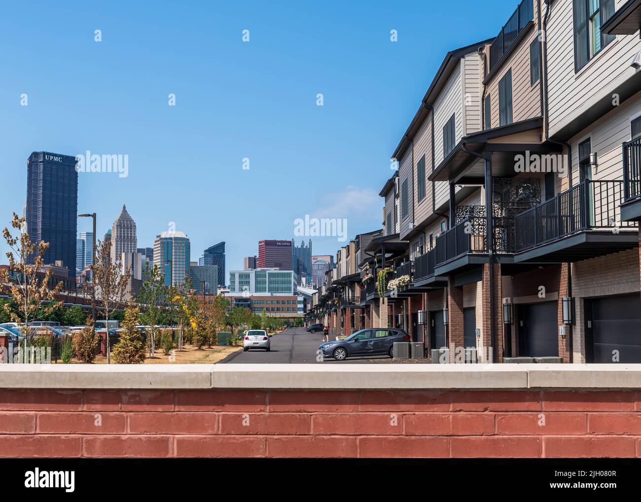 Des places de stationnement et des garages de condominium dans le complexe Riverfront Landing avec le centre-ville de Pittsburgh, Pennsylvanie, États-Unis au loin Banque D'Images