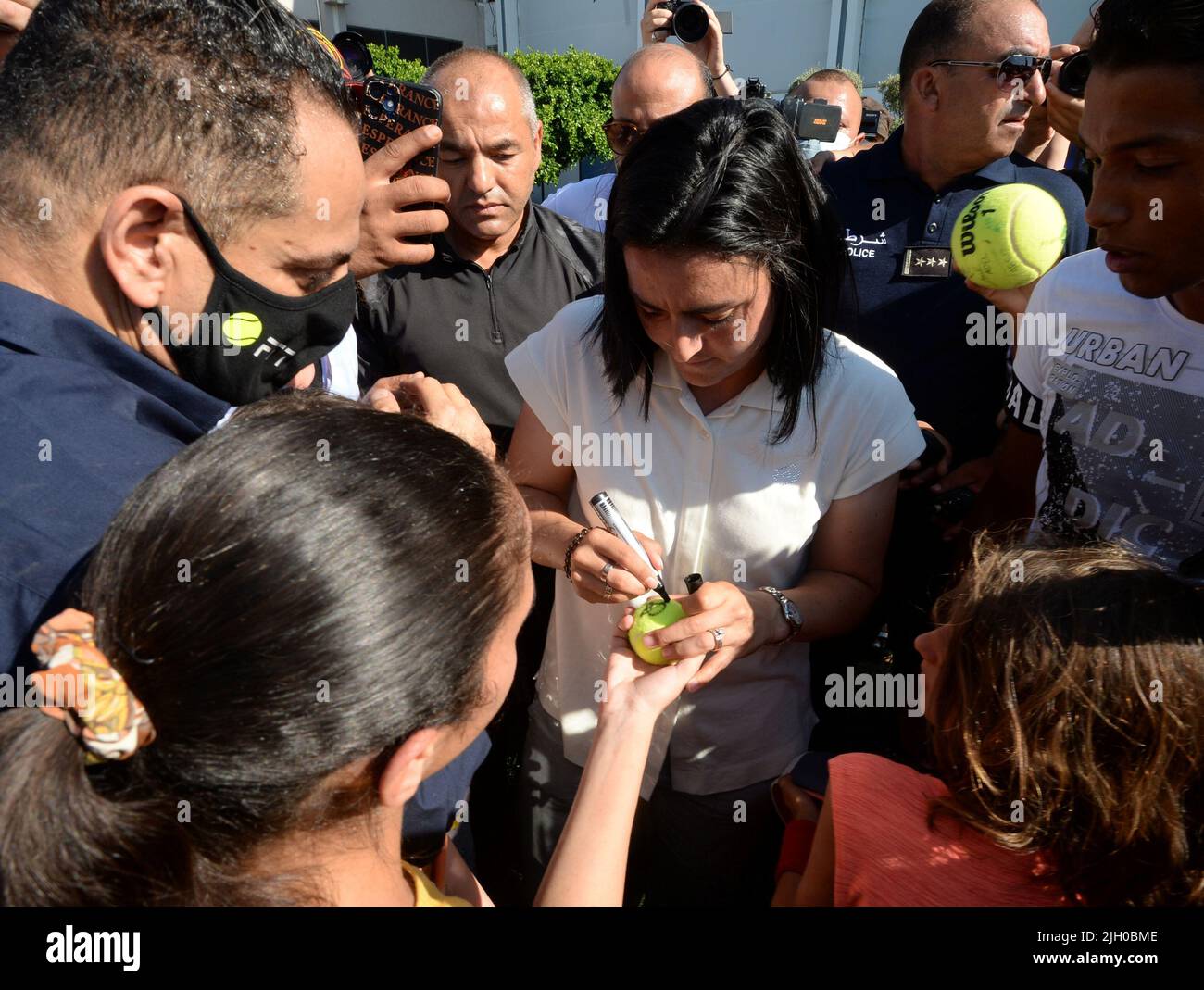 Tunis, Tunisie. 13th juillet 2022. ONS Jabeur (C) signe un autographe pour les fans après leur arrivée à Tunis, Tunisie, 13 juillet 2022. Le joueur tunisien de tennis, l'Ons Jabeur, a remporté le deuxième prix de la finale féminine des singles lors du tournoi de tennis de Wimbledon 2022 à Londres, en Angleterre, sur 9 juillet. Crédit: Adel Ezzine/Xinhua/Alamy Live News Banque D'Images