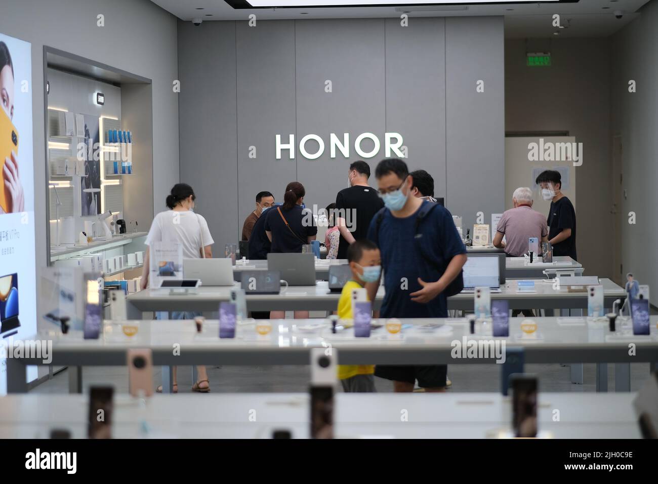 Shanghai,Chine-2 juillet 2022: Les Chinois dans le masque de visage, shopping à l'intérieur d'honneur smartphone magasin de détail. Honor est une marque de téléphone chinoise qui était auparavant propriétaire Banque D'Images