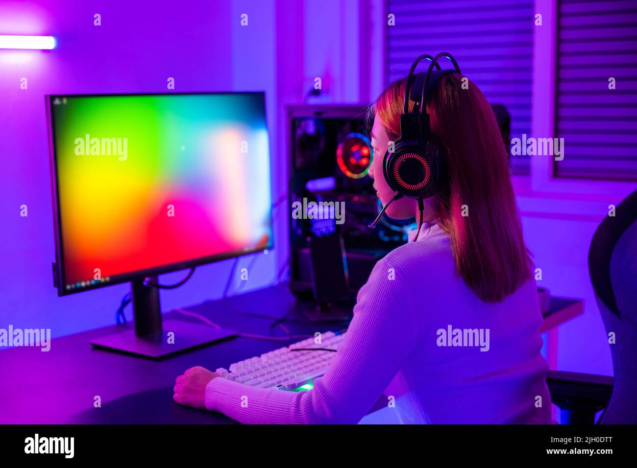 Joueur professionnel asiatique jouant en ligne jeu vidéo sur ordinateur de  bureau PC ont coloré néon LED lumières pièce sombre, jeune femme dans les  casques de jeu nous Photo Stock - Alamy