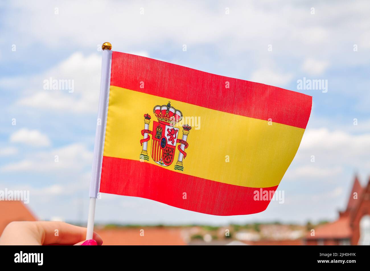 Gros plan du drapeau national espagnol jaune et rouge, drapeau de la main. Banque D'Images