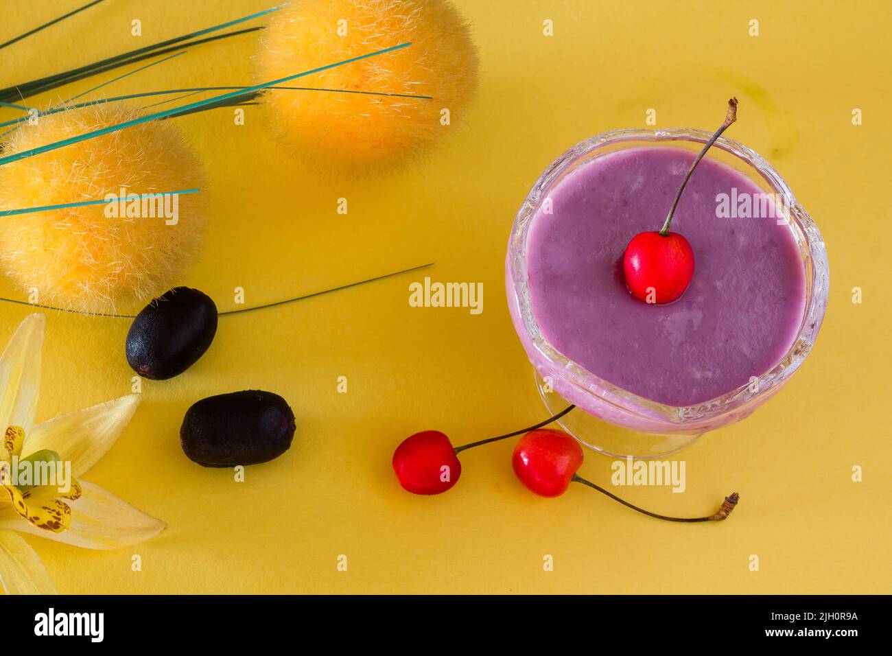 Vue de dessus, vue rapprochée de mousse Jamun ou Black Plum, avec garnitures de cerise. Dessert traditionnel d'été français isolé sur fond jaune. Espace copie. Banque D'Images