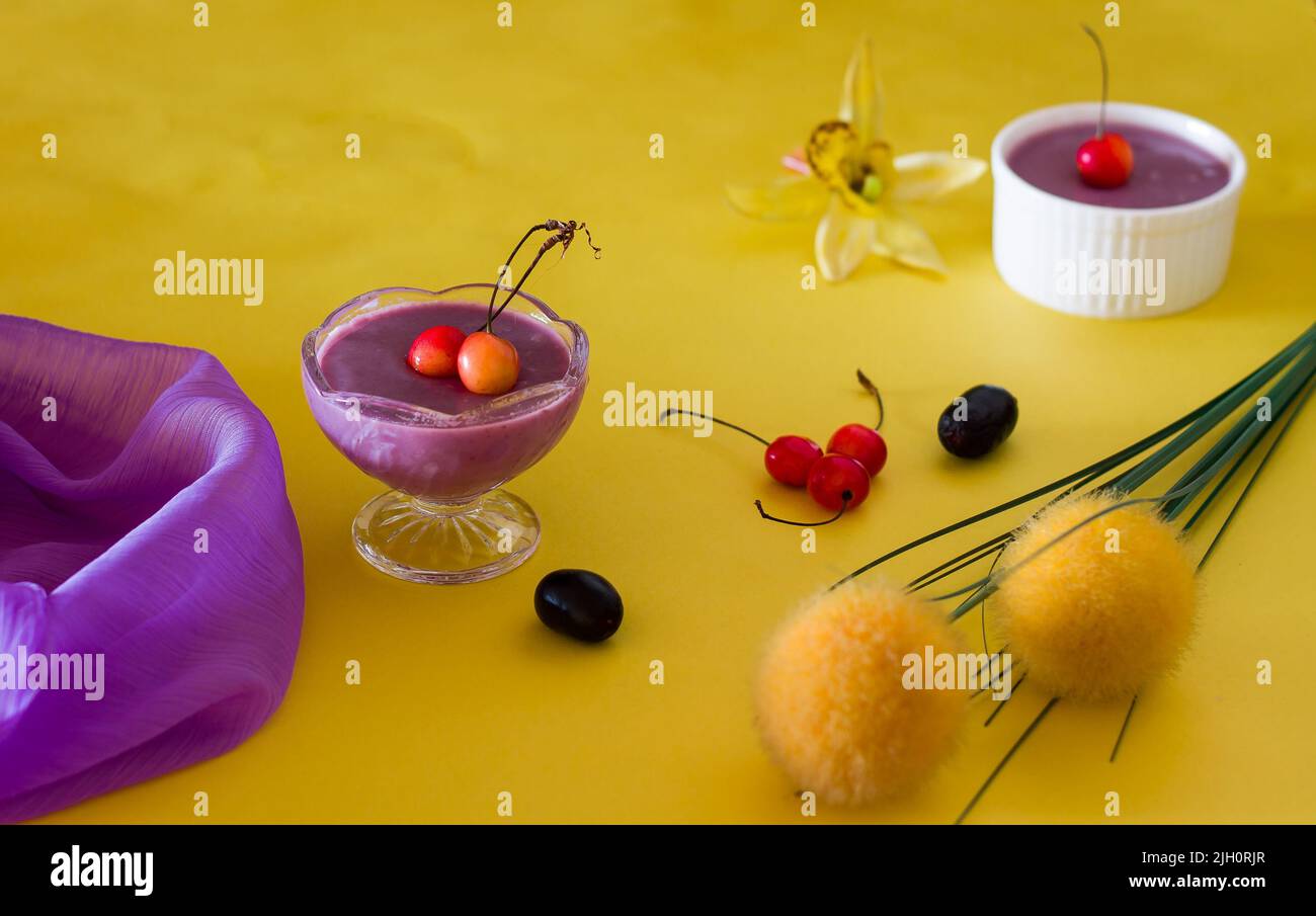Jamun Mousse, Malabar Plum mousse aux fruits avec garniture de cerise. Dessert frais fait maison à partir de Jamun. Pudding d'été sur fond jaune foncé, en gros plan. Banque D'Images