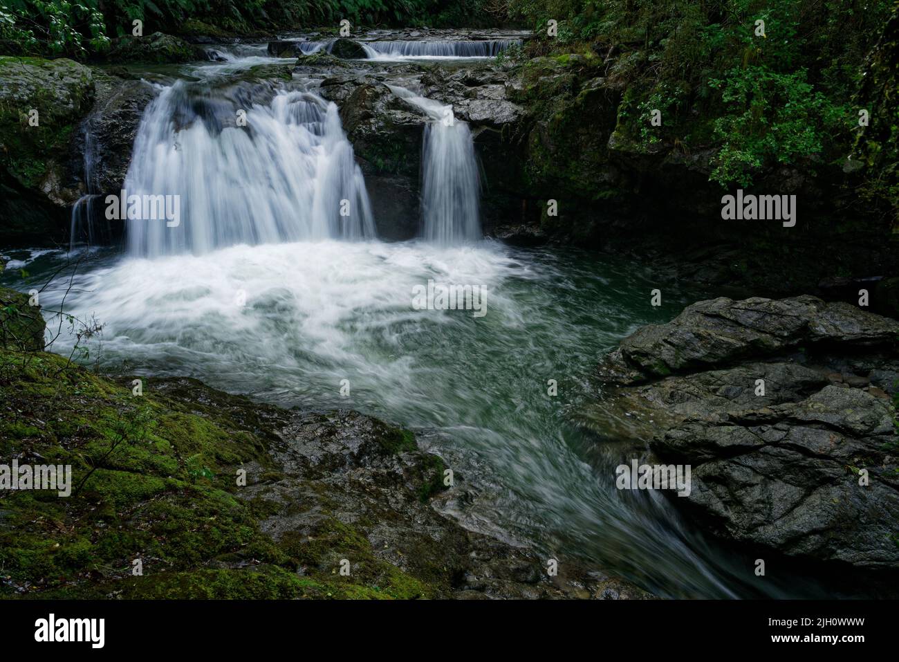 La passerelle de six Mile Creek, la rivière, la chute d'eau et les vestiges de l'ancienne centrale hydroélectrique de six Mile, Murchison, île sud, Aotearoa / Nouvelle-Zélande Banque D'Images