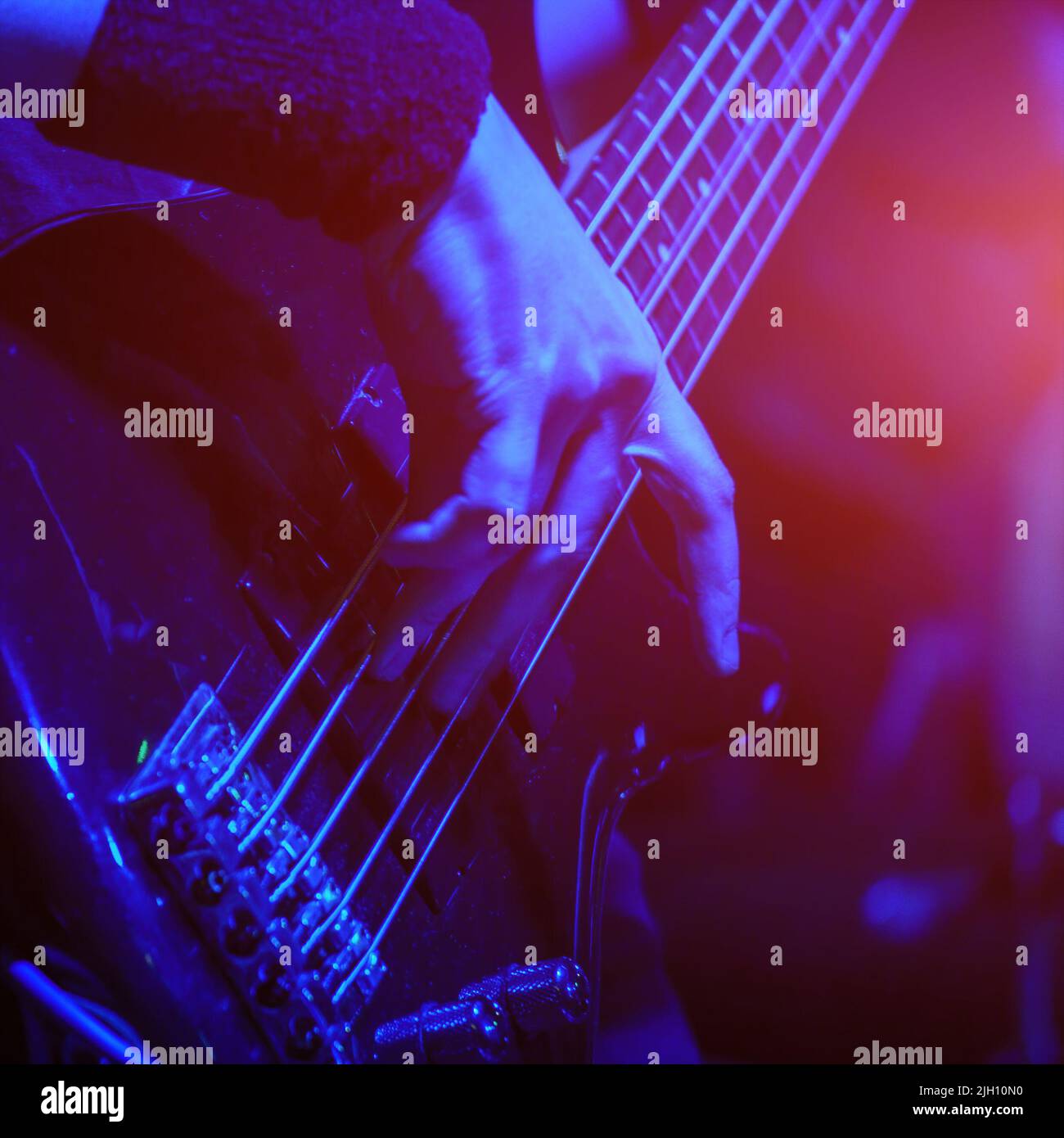 Le guitariste de basse joue la guitare de basse sous les projecteurs. Mise au point sélective Banque D'Images