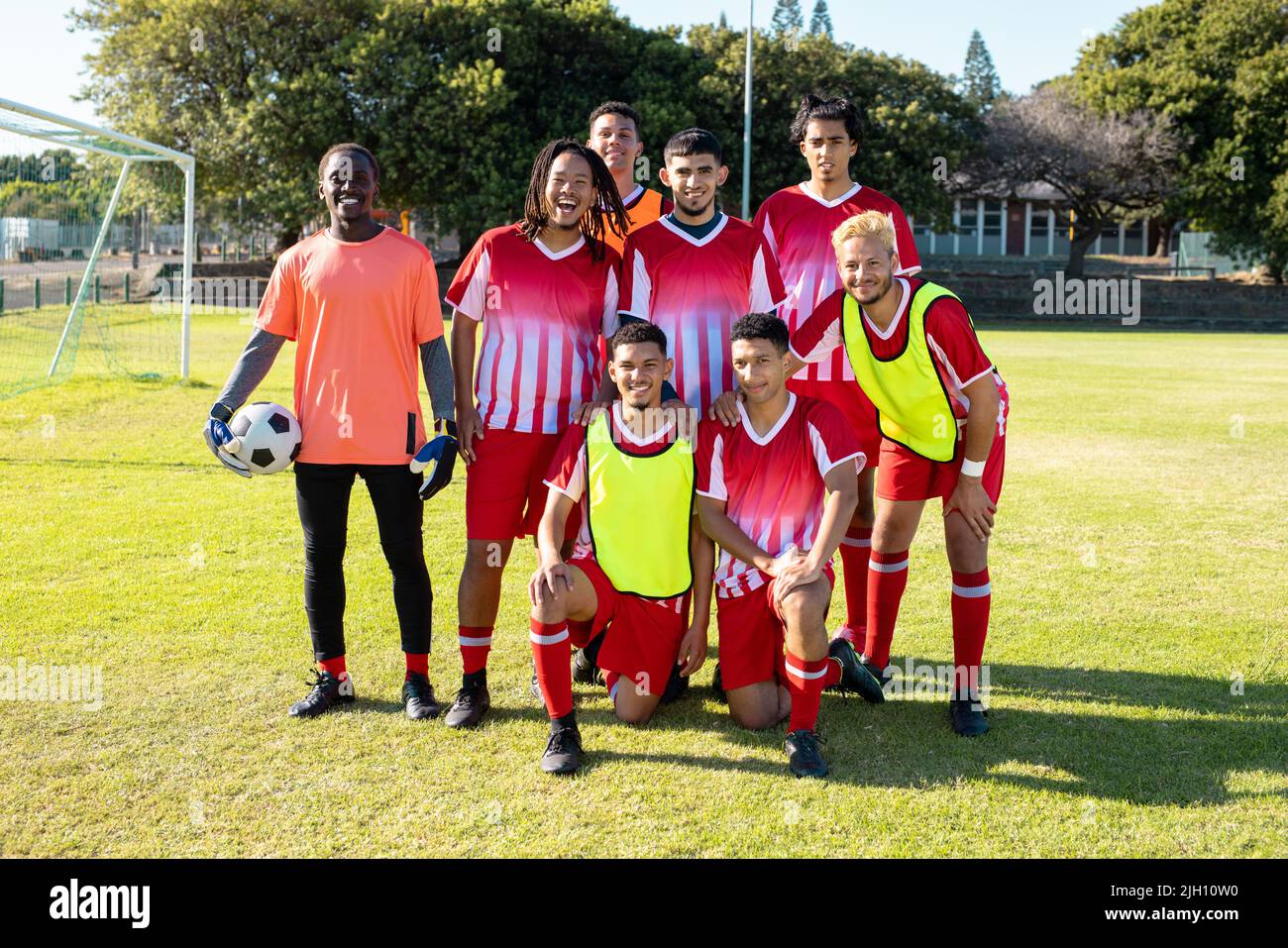 Portrait de joueurs de l'équipe de football de sexe masculin en uniforme posant dans le terrain de jeu pendant la journée ensoleillée Banque D'Images