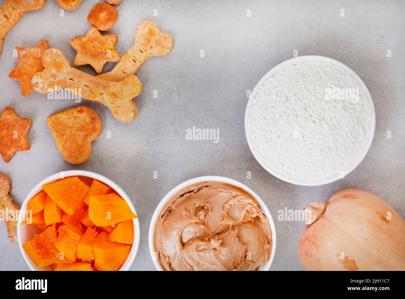 biscuits et ingrédients biologiques faits maison pour chiens sur une surface grise avec espace de copie Banque D'Images