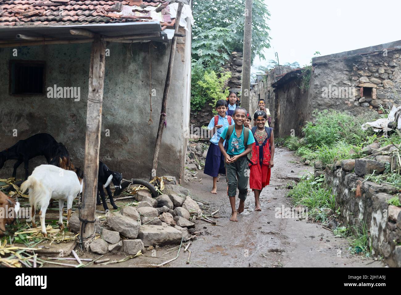 Un groupe de jeunes enfants du village indien qui vont à l'école en groupe le jour des pluies. Banque D'Images