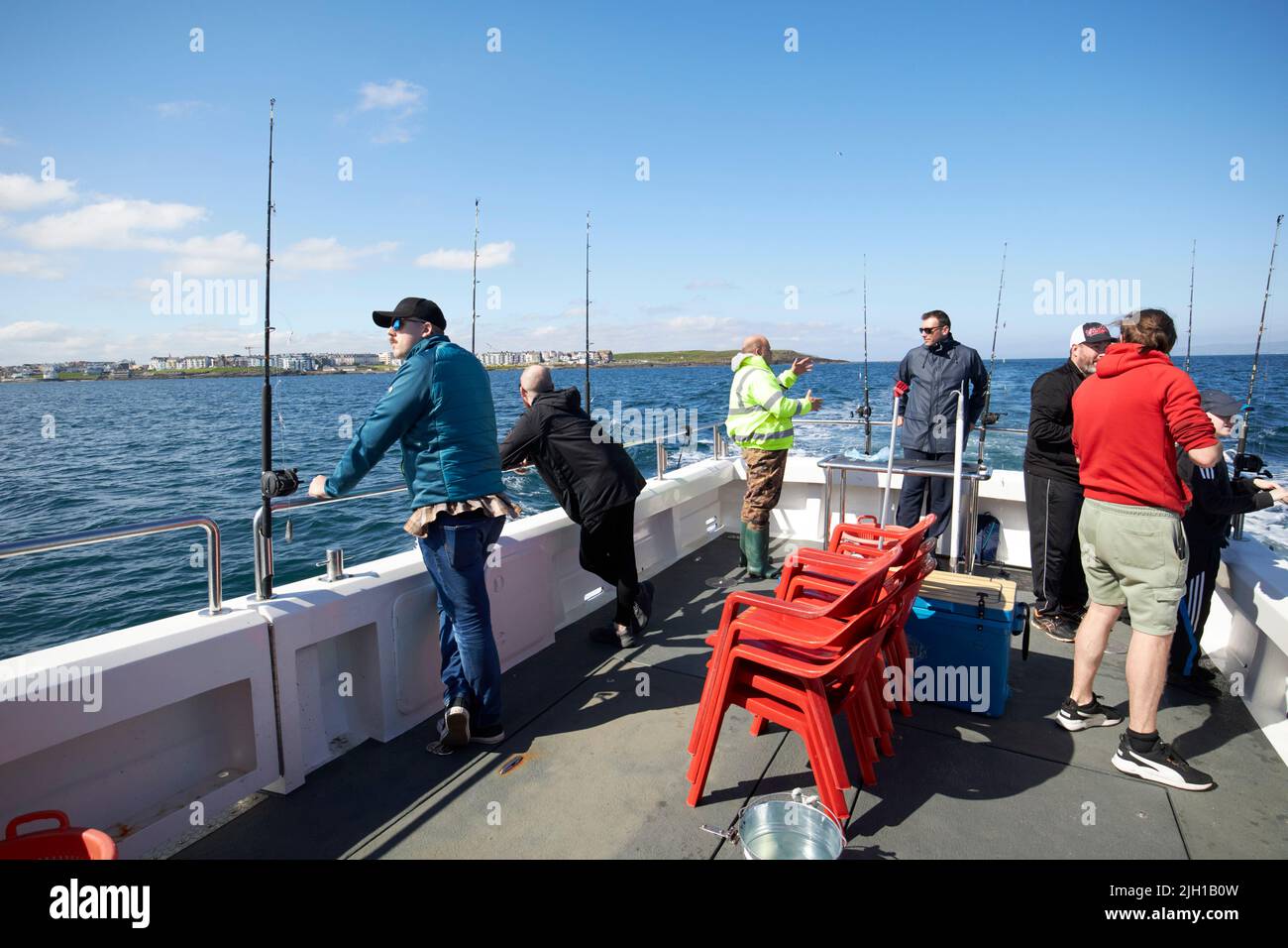 hommes sur un bateau de pêche charter en mer au large de portrush côte nord de l'irlande du nord royaume-uni Banque D'Images