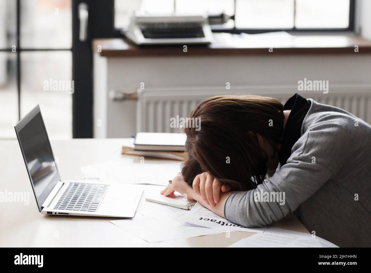 Tristes congédiés en pleurant la secrétaire féminine. Une femme a été congédiée, couchée en désespoir de cause sur son bureau de travail Banque D'Images