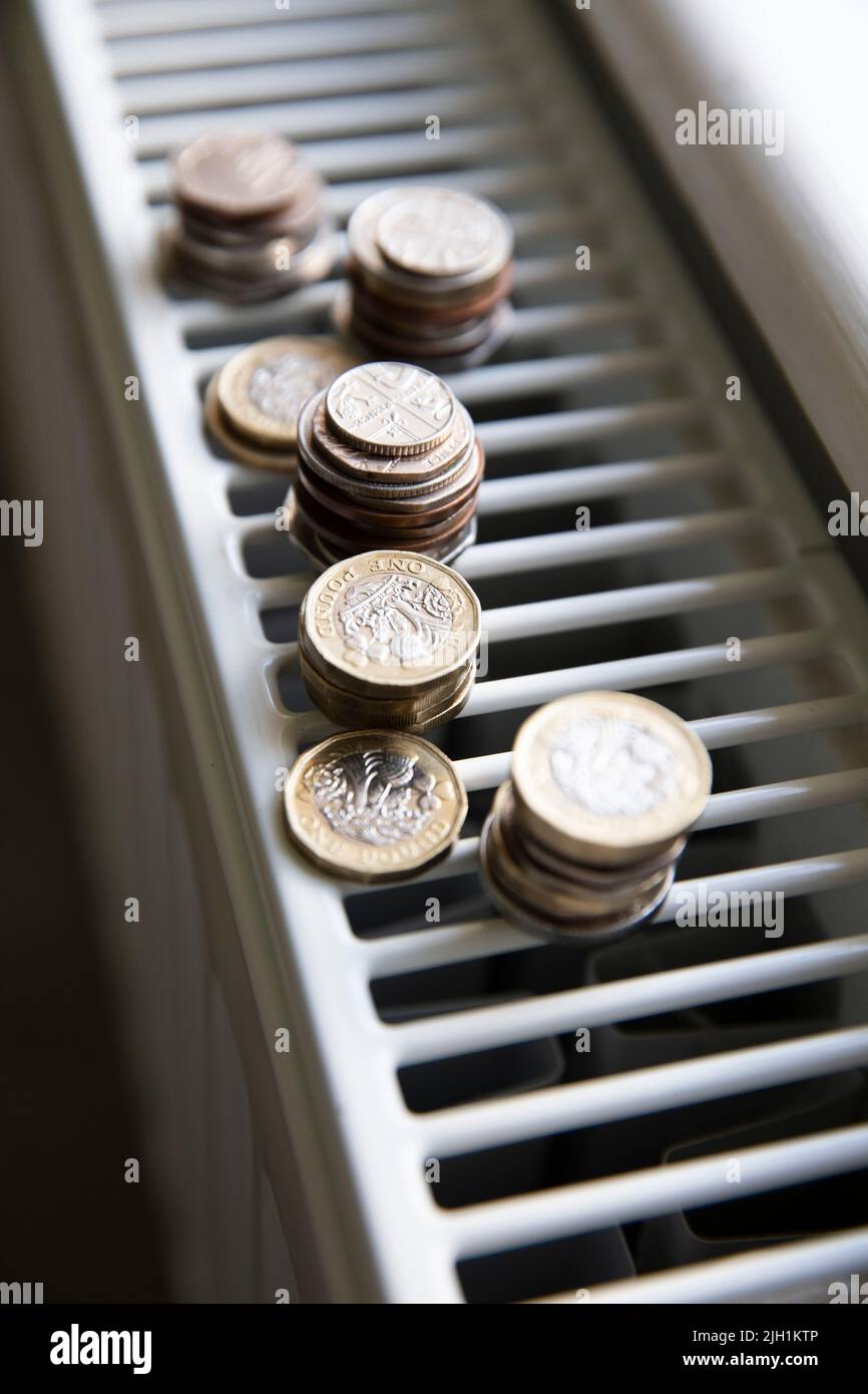 Crise du coût de la vie. De l'argent sur un radiateur de chauffage de maison. Augmentation du coût de l'énergie et des factures Banque D'Images