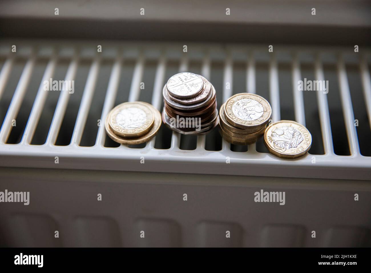 Crise du coût de la vie. De l'argent sur un radiateur de chauffage de maison. Augmentation du coût de l'énergie et des factures Banque D'Images