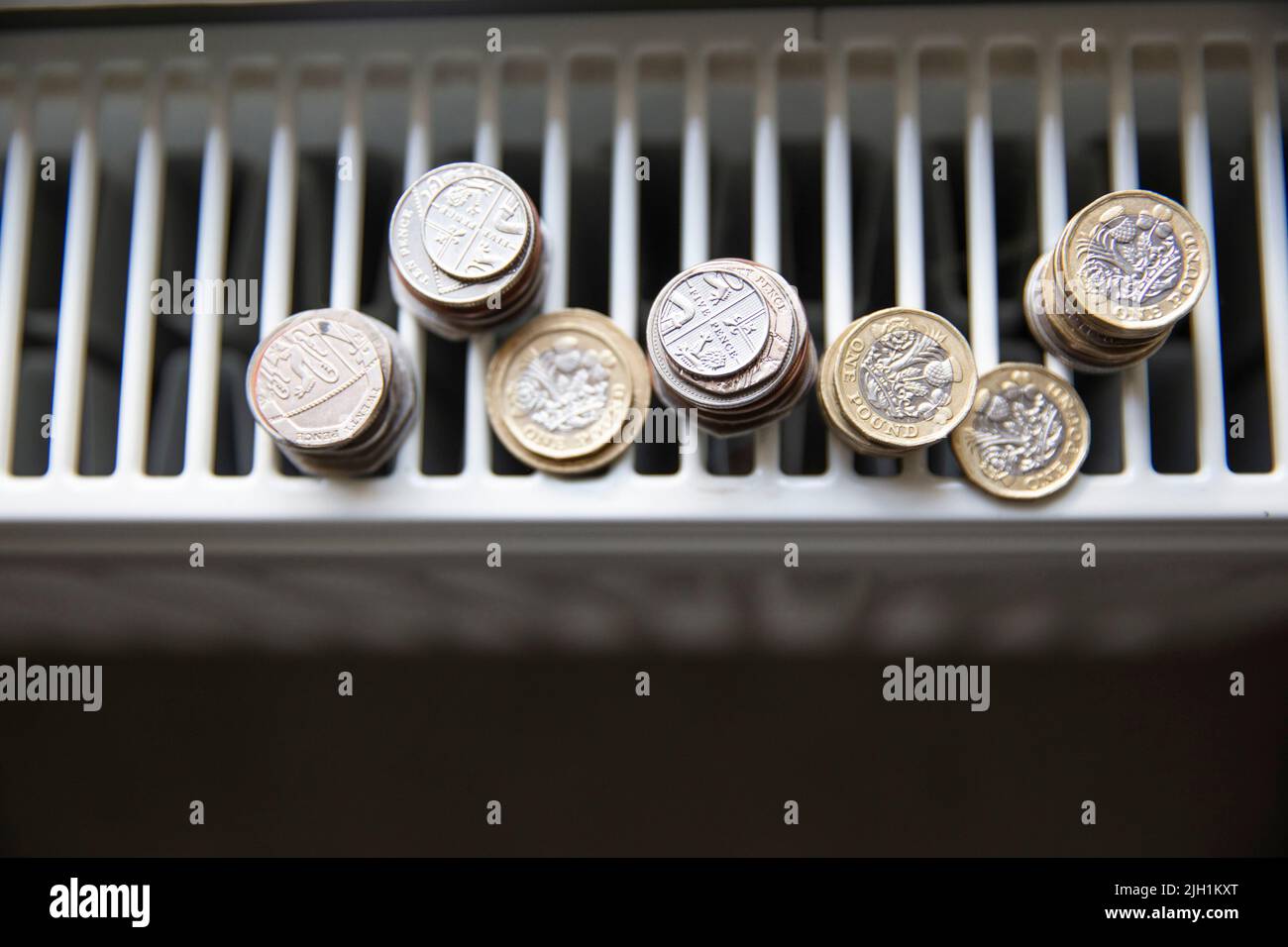 Crise du coût de la vie. De l'argent sur un radiateur de chauffage de maison. Augmentation du coût de l'énergie et des factures Banque D'Images