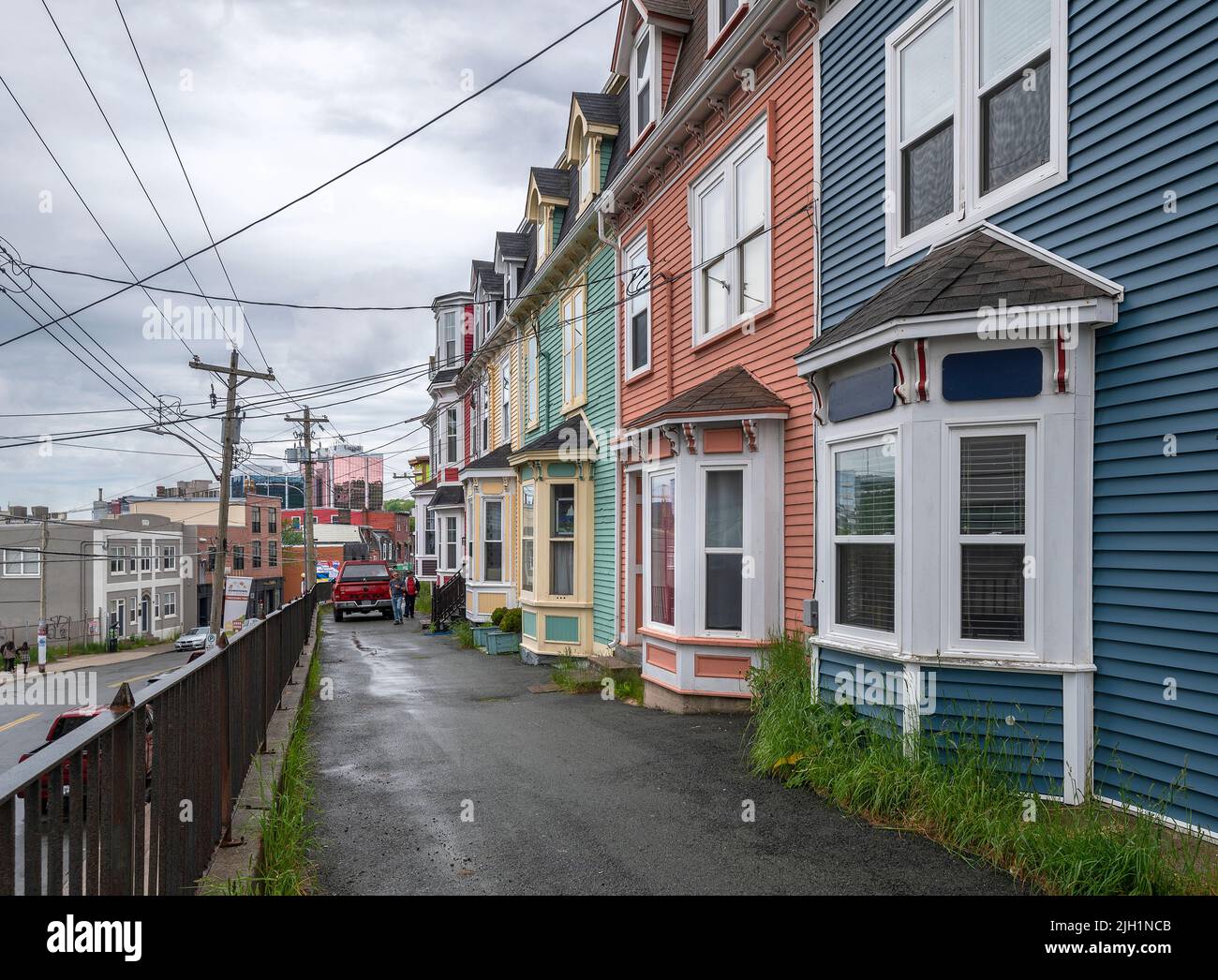 St. John’s, Terre-Neuve-et-Labrador, Canada – 21 juin 2022 : une rangée de maisons en rangée du centre-ville avec la ville en arrière-plan Banque D'Images