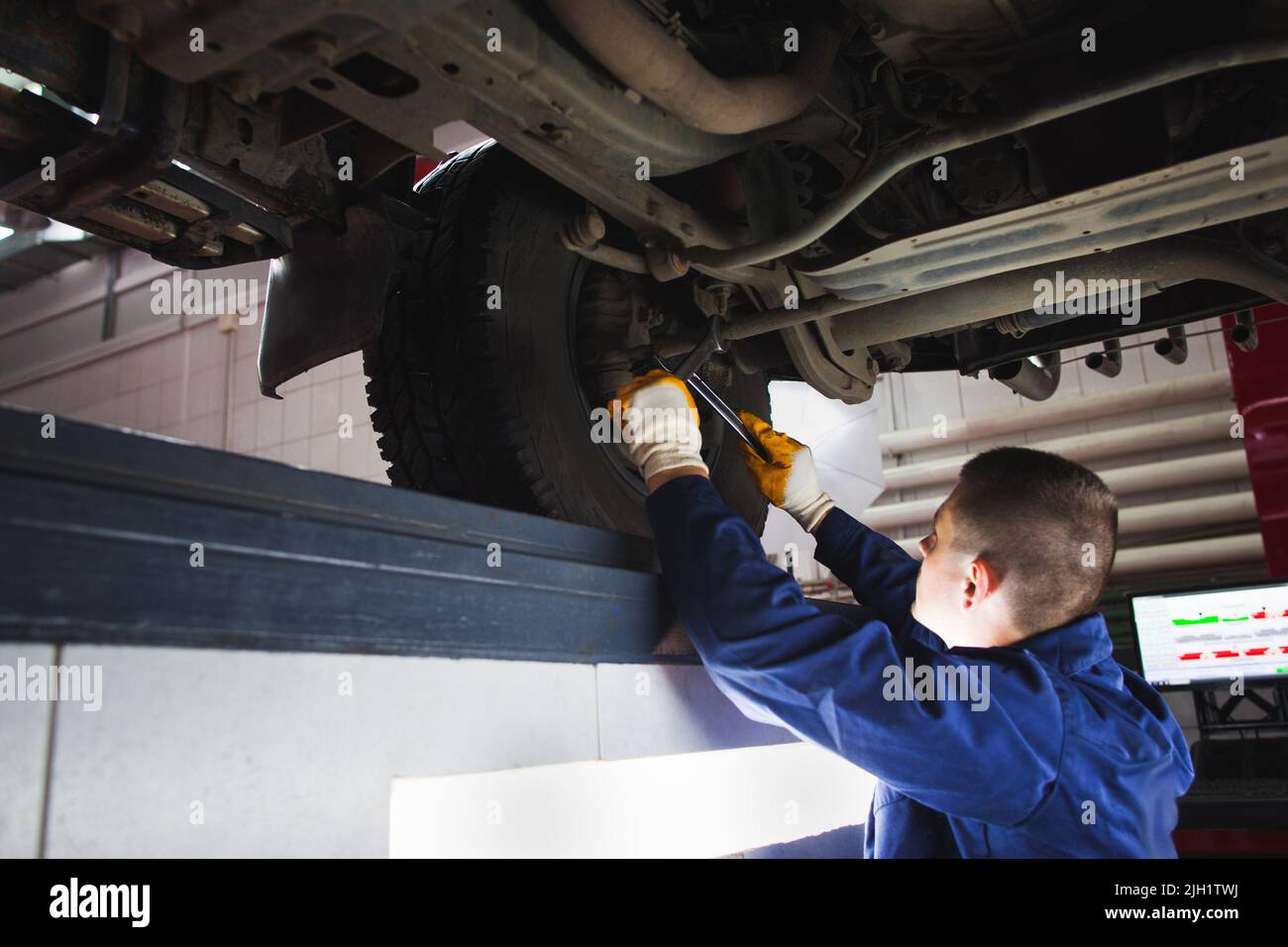 Un mécanicien récupère le système de suspension lors de l'entretien automatique Banque D'Images