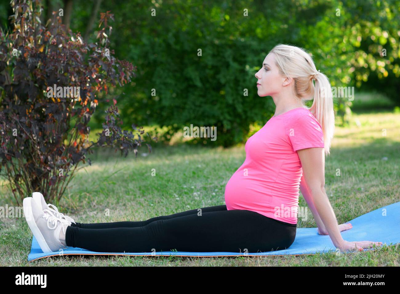 Femme enceinte assise sur un plan de karmat avec vue latérale Banque D'Images