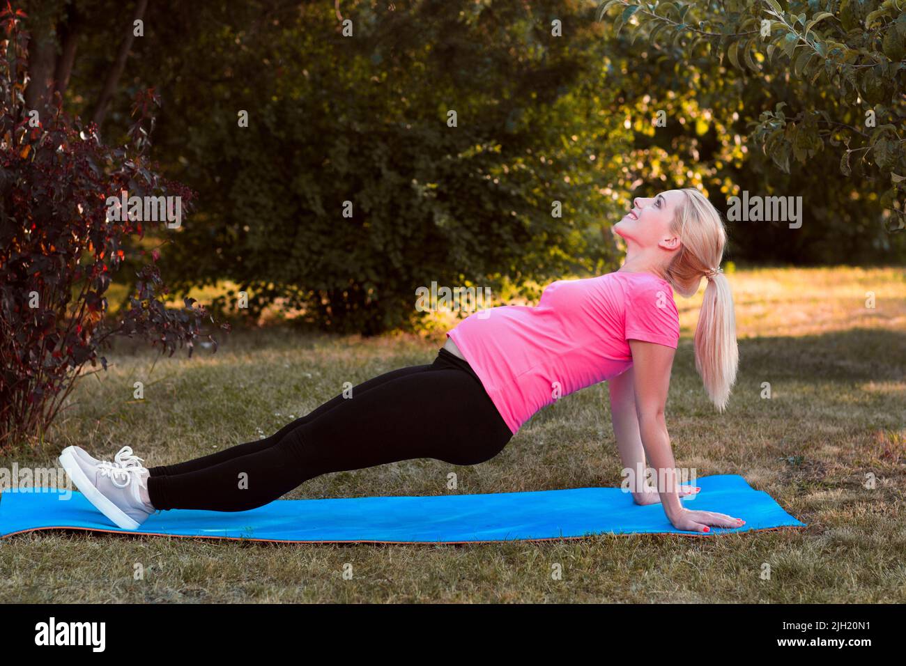 Jeune enceinte s'étirant en plein air, fitness Banque D'Images
