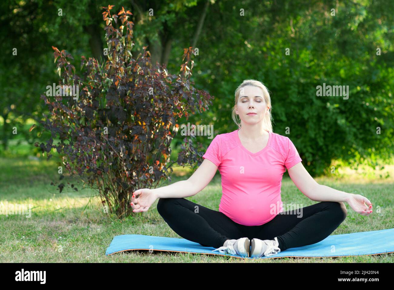 Femme enceinte médite en plein air, paysage de la nature Banque D'Images