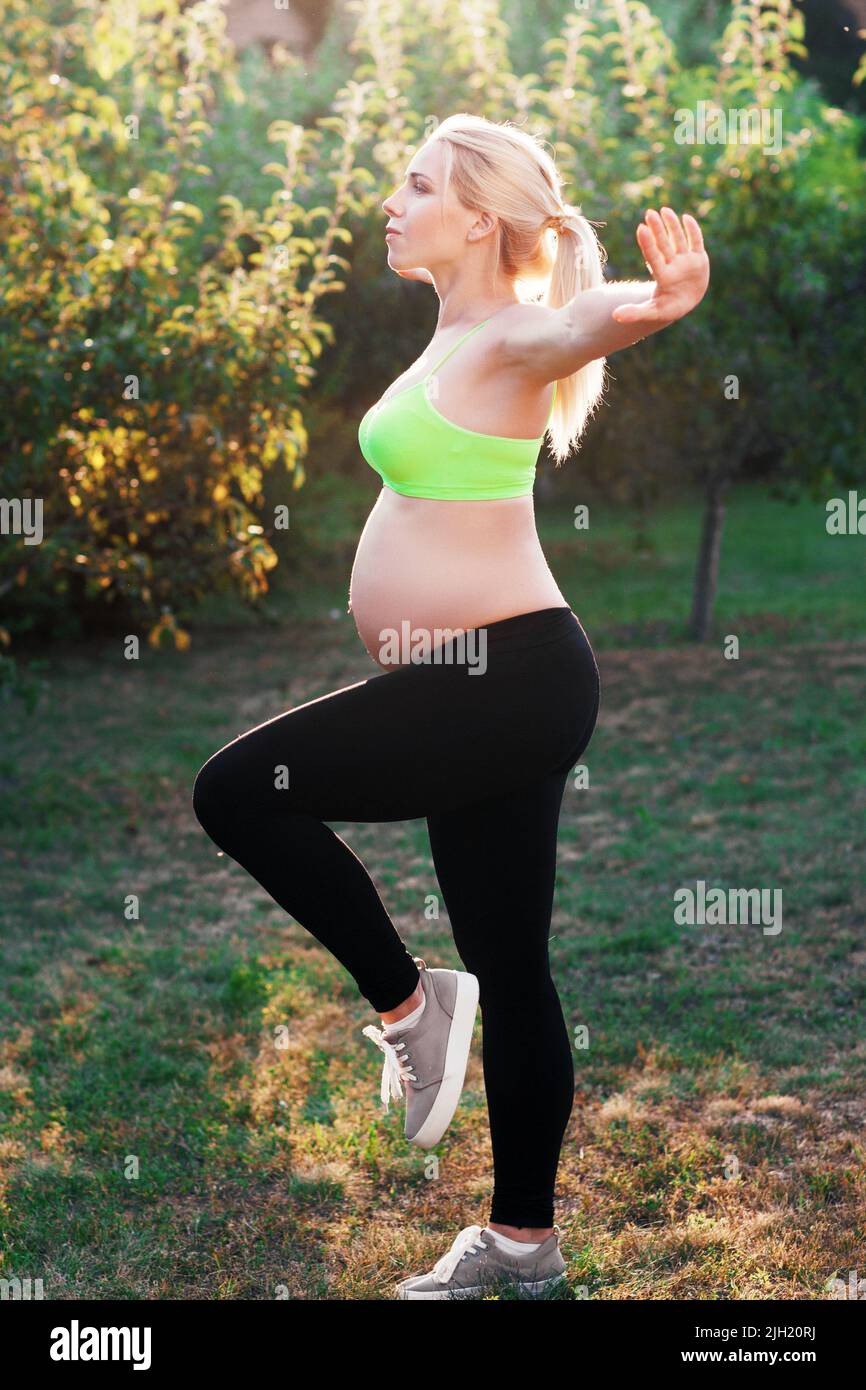 Jeune femme enceinte s'exerçant à l'extérieur Banque D'Images