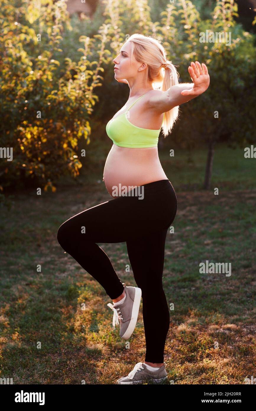 Jeune femme enceinte s'exerçant à l'extérieur Banque D'Images