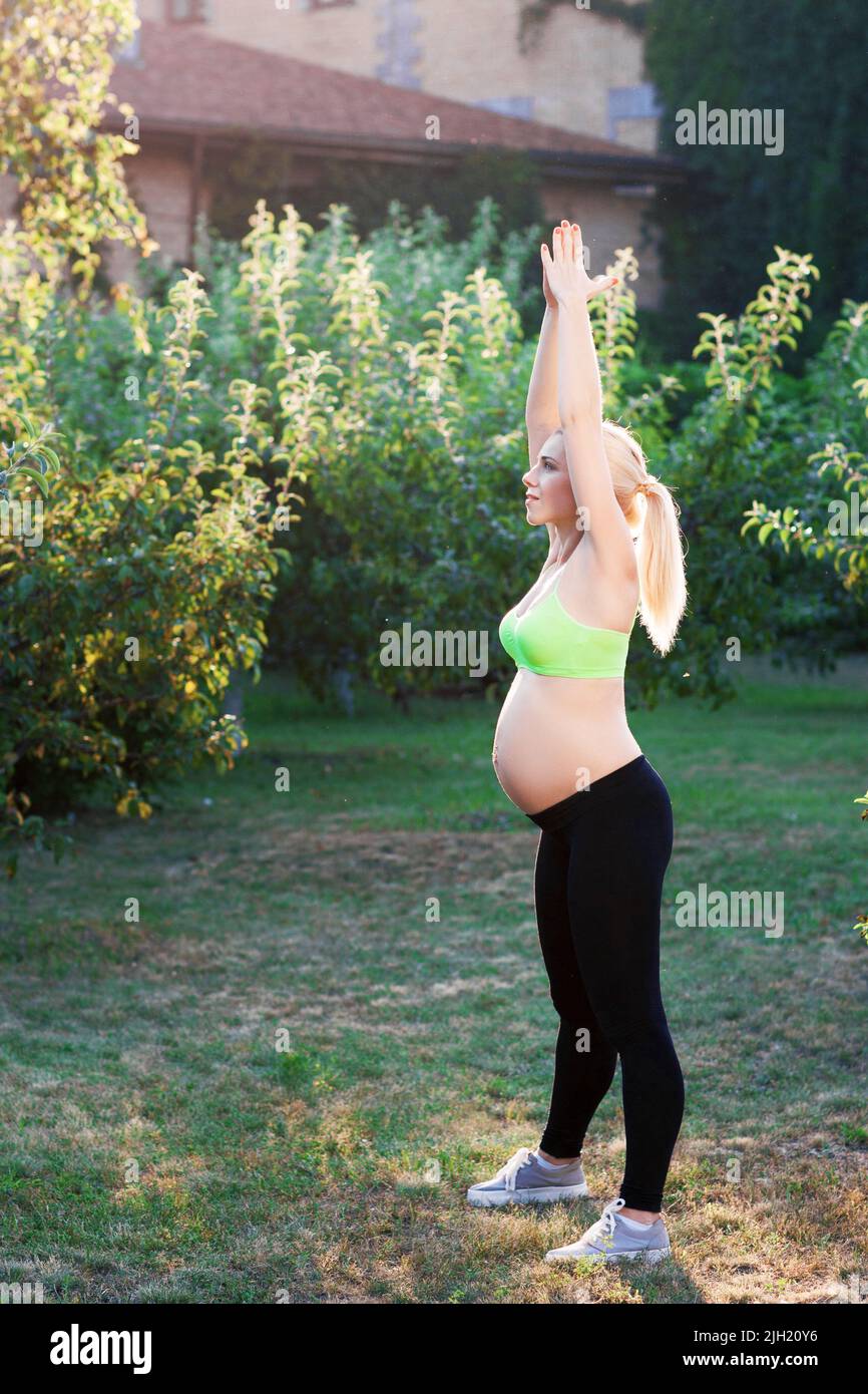 Femme enceinte se détendant à l'extérieur, espace libre Banque D'Images