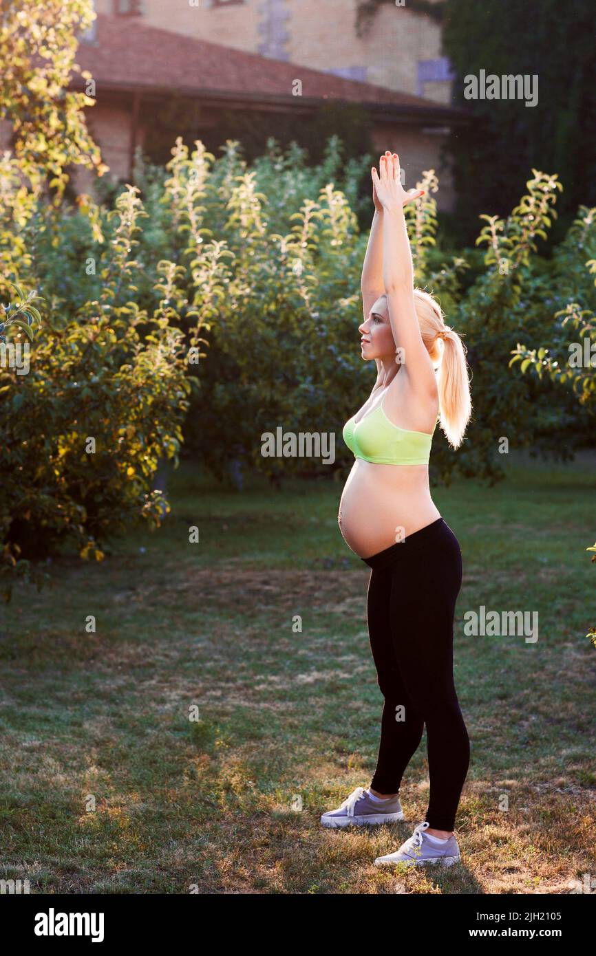 Femme enceinte se détendant à l'extérieur, espace libre Banque D'Images