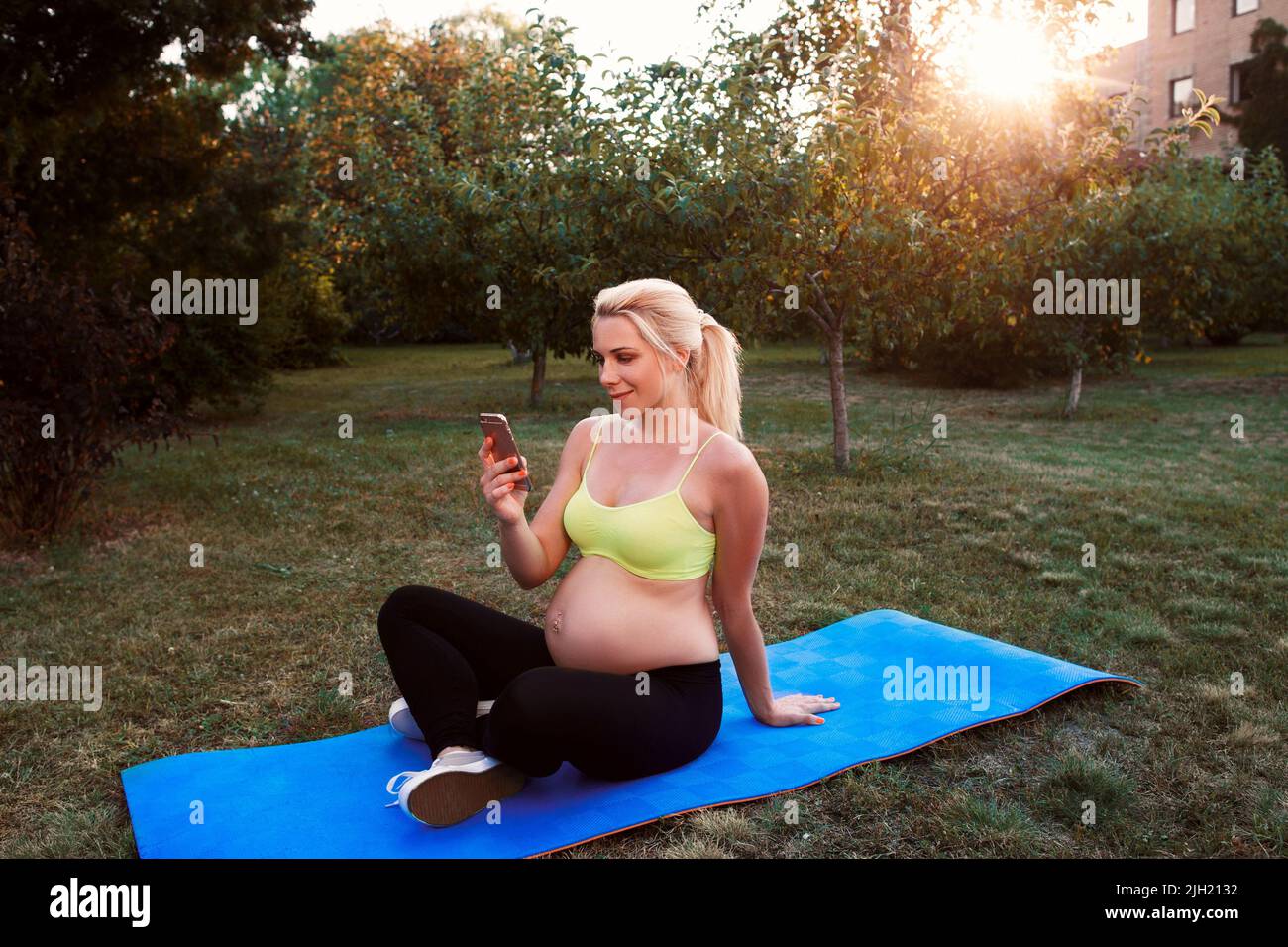 Femme souriante discutant sur un smartphone en extérieur Banque D'Images