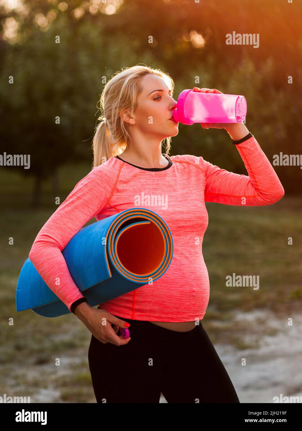Femme enceinte qui boit de l'eau après la remise en forme Banque D'Images