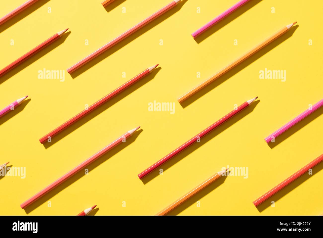 Imaginez des crayons de différentes nuances de rose sur fond jaune Banque D'Images